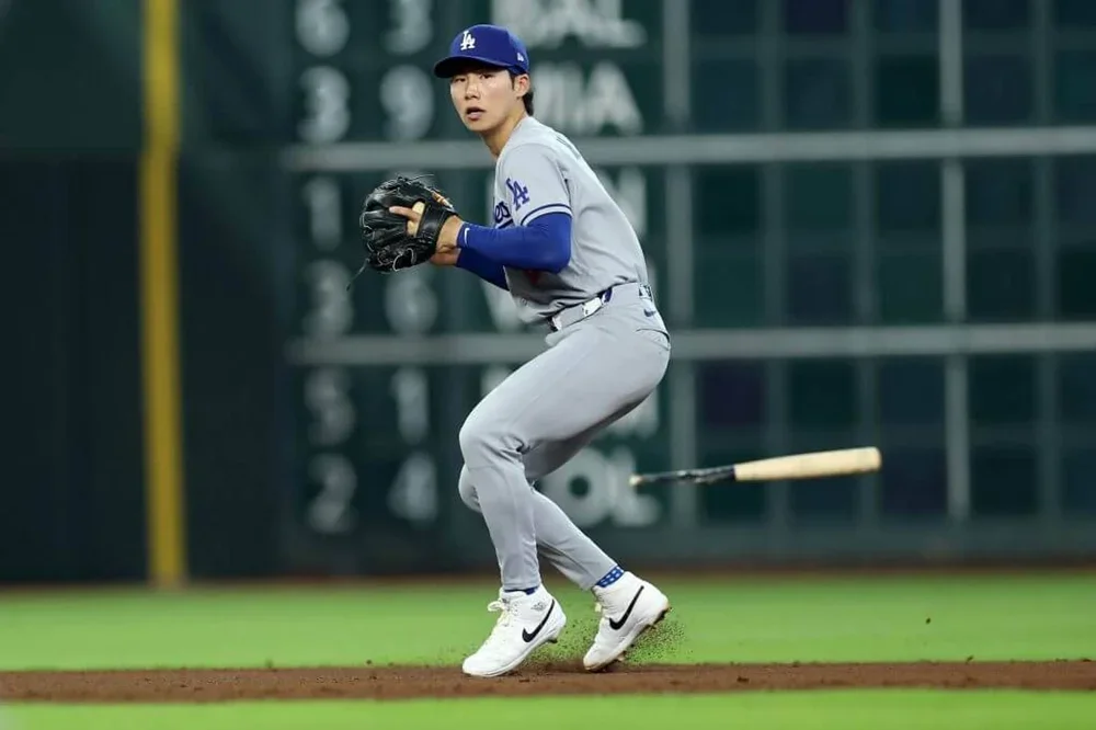Los Angeles Dodgers shortstop Hyeseong Kim avoids a broken bat as he prepares to throw to first base during a game against the Houston Astros on May 6, 2026.